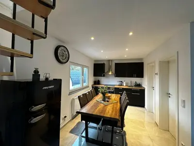a kitchen with a wooden table and chairs in a room at Ferienvilla 10 Minuten vom Strand in Dirkshorn