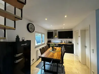 a kitchen with a wooden table and chairs in it at Ferienvilla 10 Minuten vom Strand in Dirkshorn
