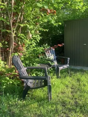 two benches sitting in the grass in a yard at Beautiful Amstel houseboat in Amsterdam