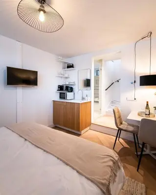 a bedroom with a bed and a kitchen with a table at Beautiful Amstel houseboat in Amsterdam