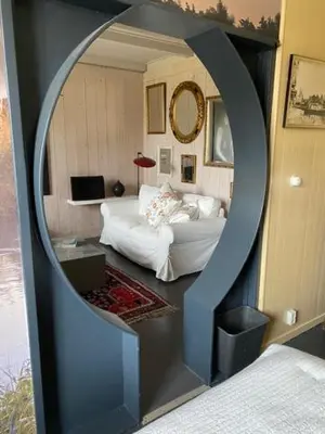 a room with a bedroom with a bed and a mirror at Ingeborgh Art Gastenverblijf in Grootschermer