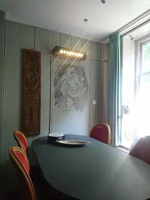 a dining room with a table and chairs and a window at Ingeborgh Art Gastenverblijf in Grootschermer
