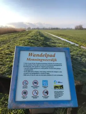 a sign in the middle of a field at Ingeborgh Art Gastenverblijf in Grootschermer