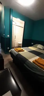 a room with two beds and a table and a window at JONI, not for parties, not a hotel, room with no kitchen in Amsterdam