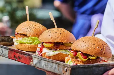 three sandwiches on a tray with wooden sticks at Postillion Amersfoort Veluwemeer in Putten
