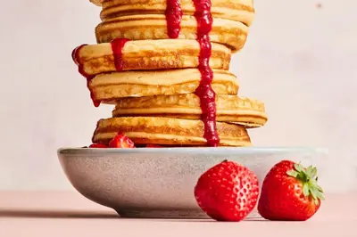 a stack of pancakes with strawberries on a plate at Postillion Amersfoort Veluwemeer in Putten