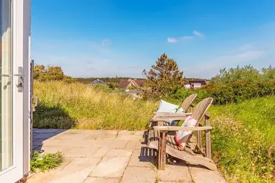 two chairs sitting on a patio outside of a house at Beach house Alba in Bergen aan Zee