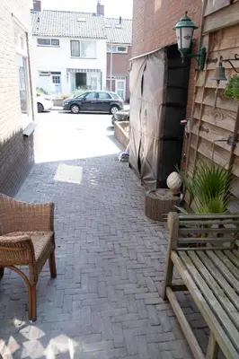 a patio with a bench and a building at 'T Heilige Pad in Egmond aan Zee