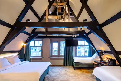 a attic bedroom with two beds and a couch at Mister Highland Hotel in Amsterdam