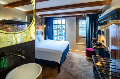 a hotel room with a bed and a tub and a sink at Mister Highland Hotel in Amsterdam