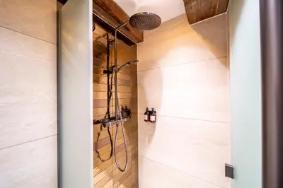 a shower in a bathroom with wooden walls at Mister Highland Hotel in Amsterdam