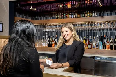 two women standing at a counter in a bar at Mister Highland Hotel in Amsterdam
