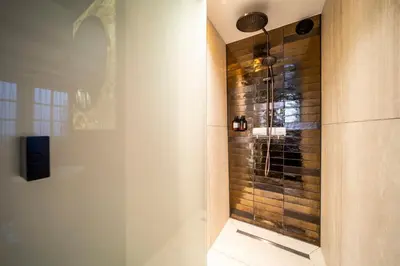 a shower with a glass door in a bathroom at Mister Highland Hotel in Amsterdam