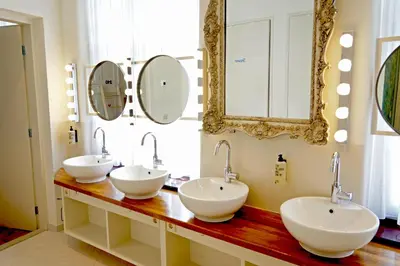 a bathroom with three sinks and a mirror at De Bedstee Boutique Capsules in Amsterdam