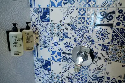 a bathroom with blue and white tiles on the wall at De Bedstee Boutique Capsules in Amsterdam