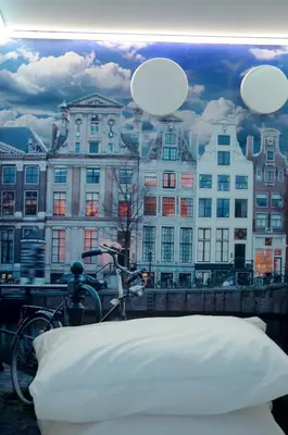 a bike parked next to a bedroom with a view of buildings at De Bedstee Boutique Capsules in Amsterdam