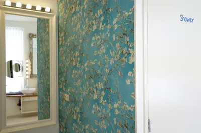 a bathroom with a green wall with a mirror at De Bedstee Boutique Capsules in Amsterdam