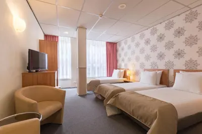 a hotel room with two beds and a tv at Rho Hotel in Amsterdam