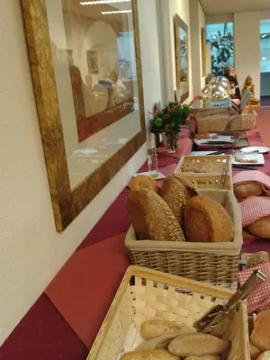 a bakery with baskets of bread on a table at Rho Hotel in Amsterdam