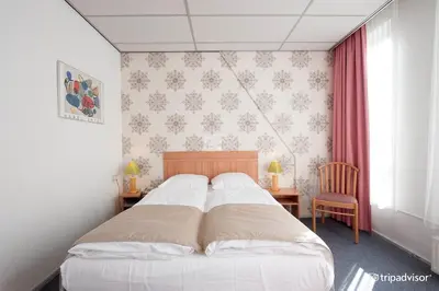 a bedroom with a bed and a desk and a window at Rho Hotel in Amsterdam