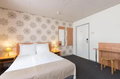 a bedroom with a bed with two tables and two lamps at Rho Hotel in Amsterdam