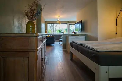a bedroom with a bed with a dresser and a desk at City Design Studio in Alkmaar