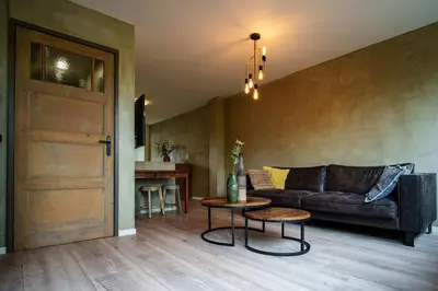 a living room with a couch and a table and a door at City Design Studio in Alkmaar