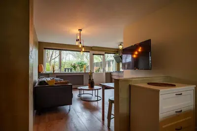 a kitchen and living room with a table and a tv at City Design Studio in Alkmaar