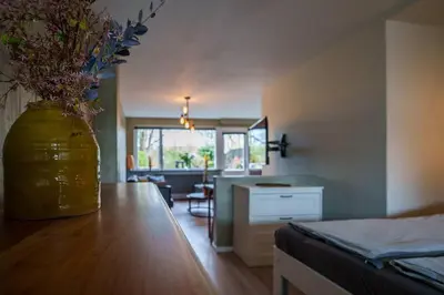 a room with a vase with flowers on a wooden table at City Design Studio in Alkmaar