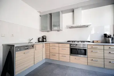 a kitchen with wooden cabinets and a stove top oven at CityHouse Alkmaar in Alkmaar