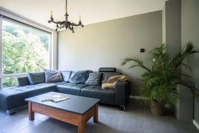 a living room with a blue couch and a table at CityHouse Alkmaar in Alkmaar