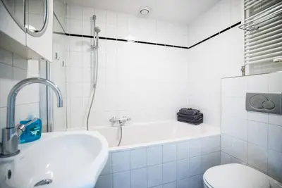 a bathroom with a tub and a sink and a toilet at CityHouse Alkmaar in Alkmaar