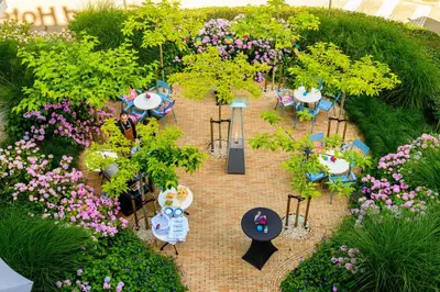 an overhead view of a garden with tables and chairs and flowers at Grand Hotel Amstelveen in Amstelveen