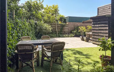a table and chairs in a backyard with a garden at Stunning Home In Noordwijk With Wifi in Noordwijk aan Zee
