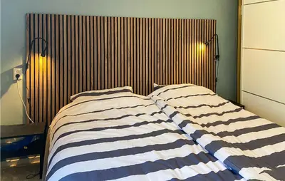 a bedroom with a bed with a striped blanket at Stunning Home In Noordwijk With Wifi in Noordwijk aan Zee