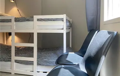 a room with a chair and a bunk bed at Stunning Home In Noordwijk With Wifi in Noordwijk aan Zee