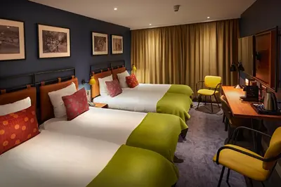 a hotel room with two beds and a desk at Hotel Lion D'Or in Haarlem