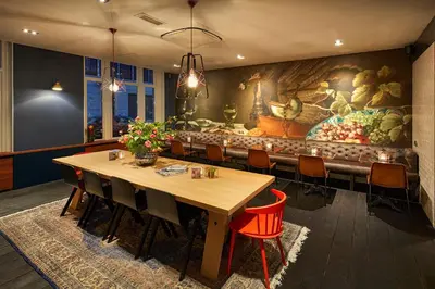 a dining room with a large painting on the wall at Hotel Lion D'Or in Haarlem