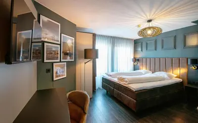 a hotel room with a bed and a lamp at Hotel Old Dutch in Volendam