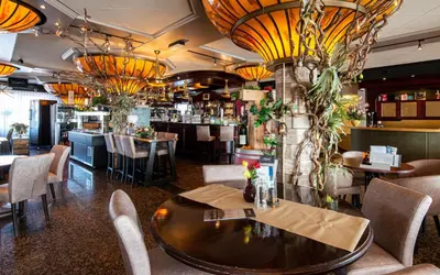 a restaurant with tables and chairs and a bar at Hotel Old Dutch in Volendam