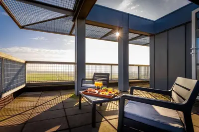 a balcony with a tray of fruit on a table at Ramada by Wyndham Amsterdam Airport Schiphol in Badhoevedorp
