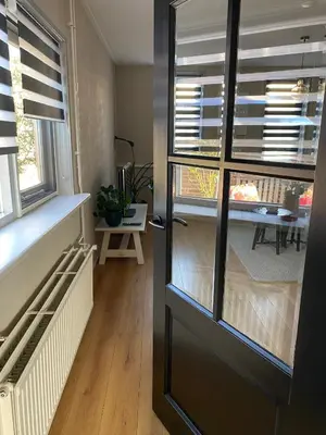 a room with blinds on a window and a table at Guesthouse Katwijk aan Zee in Katwijk aan Zee