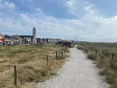 a dirt road in a field with a ferris wheel at Guesthouse Katwijk aan Zee in Katwijk aan Zee