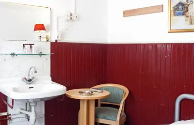 a bathroom with a sink and a chair at De Mallemoolen in Amsterdam