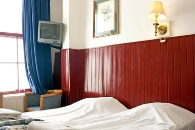 a bedroom with a bed and a tv on a wall at De Mallemoolen in Amsterdam