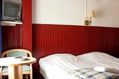a bedroom with a bed and a table and a tv at De Mallemoolen in Amsterdam