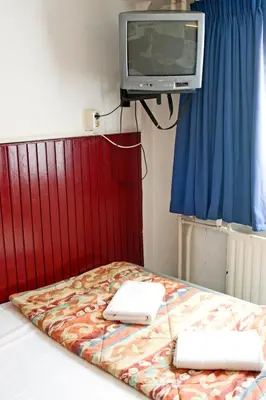 a room with a bed with a tv on the wall at De Mallemoolen in Amsterdam
