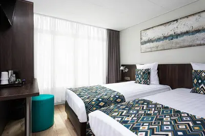 a hotel room with two beds and a window at Hotel Damsquare in Amsterdam