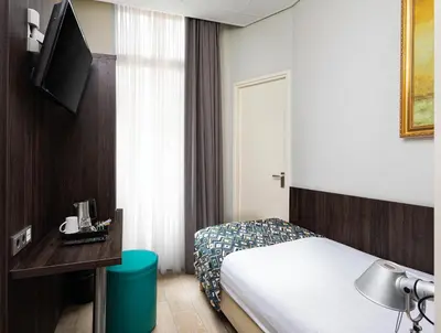 a hotel room with a bed and a television at Hotel Damsquare in Amsterdam