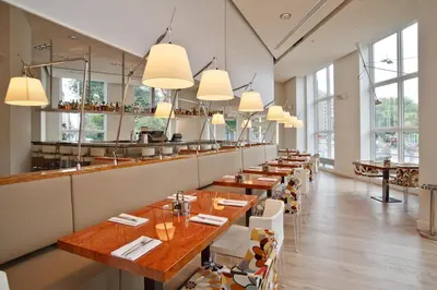 a row of tables in a restaurant with windows at Park Centraal Amsterdam, part of Sircle Collection in Amsterdam
